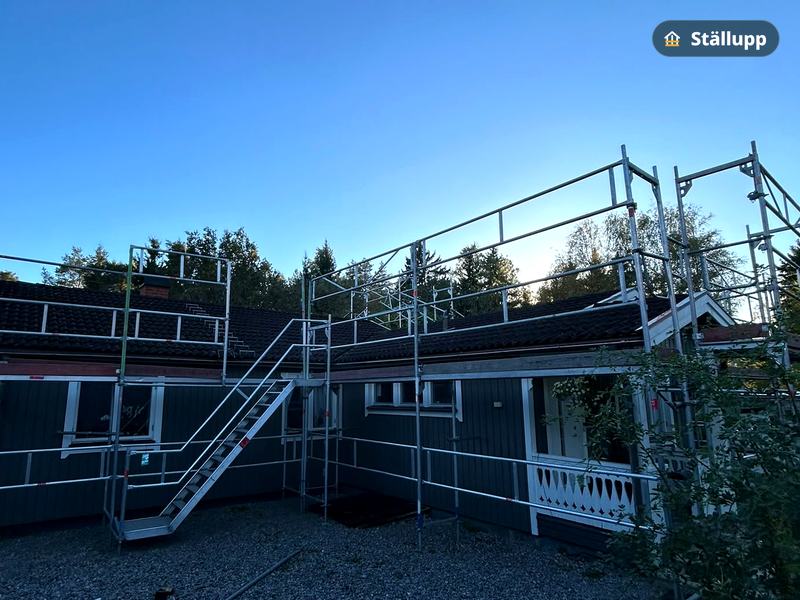 Ställning längs takfoten med trapptorn på en mörk trävilla