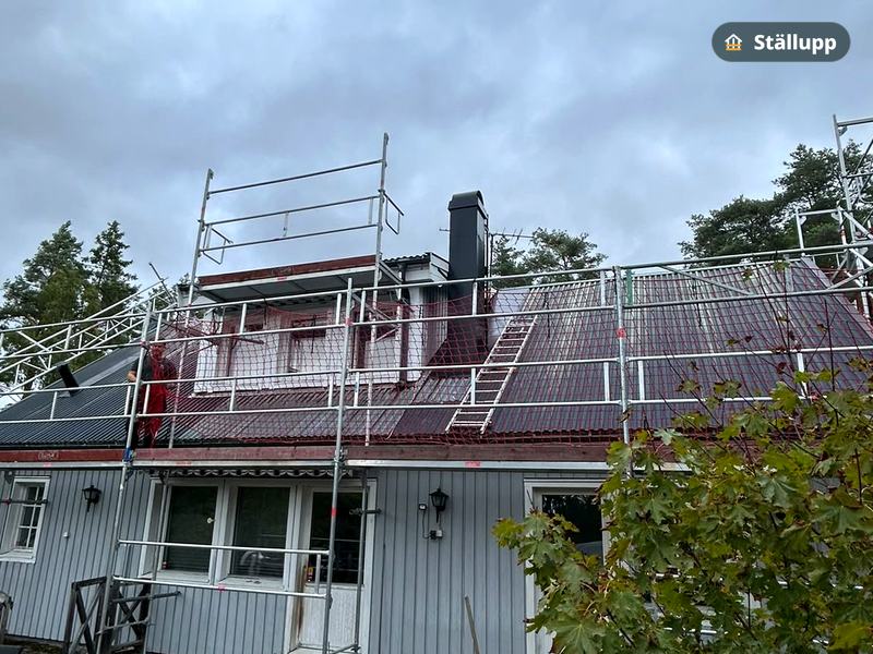 Takställning med skyddsräcke runt ett rött tak
