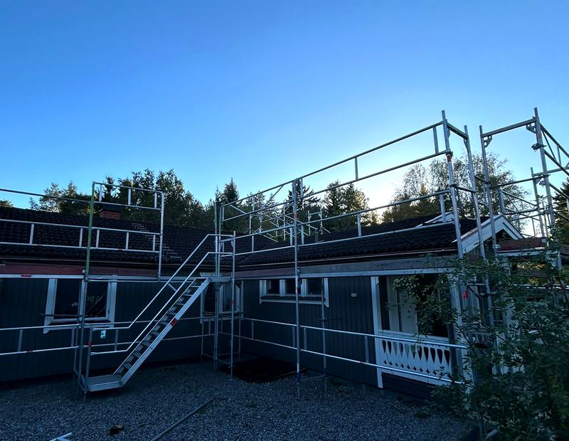Ställning längs takfoten med trapptorn på en mörk trävilla